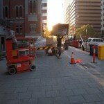 Tate manhandles a box in the morning glow of St Georges Terrace on morning of opening party